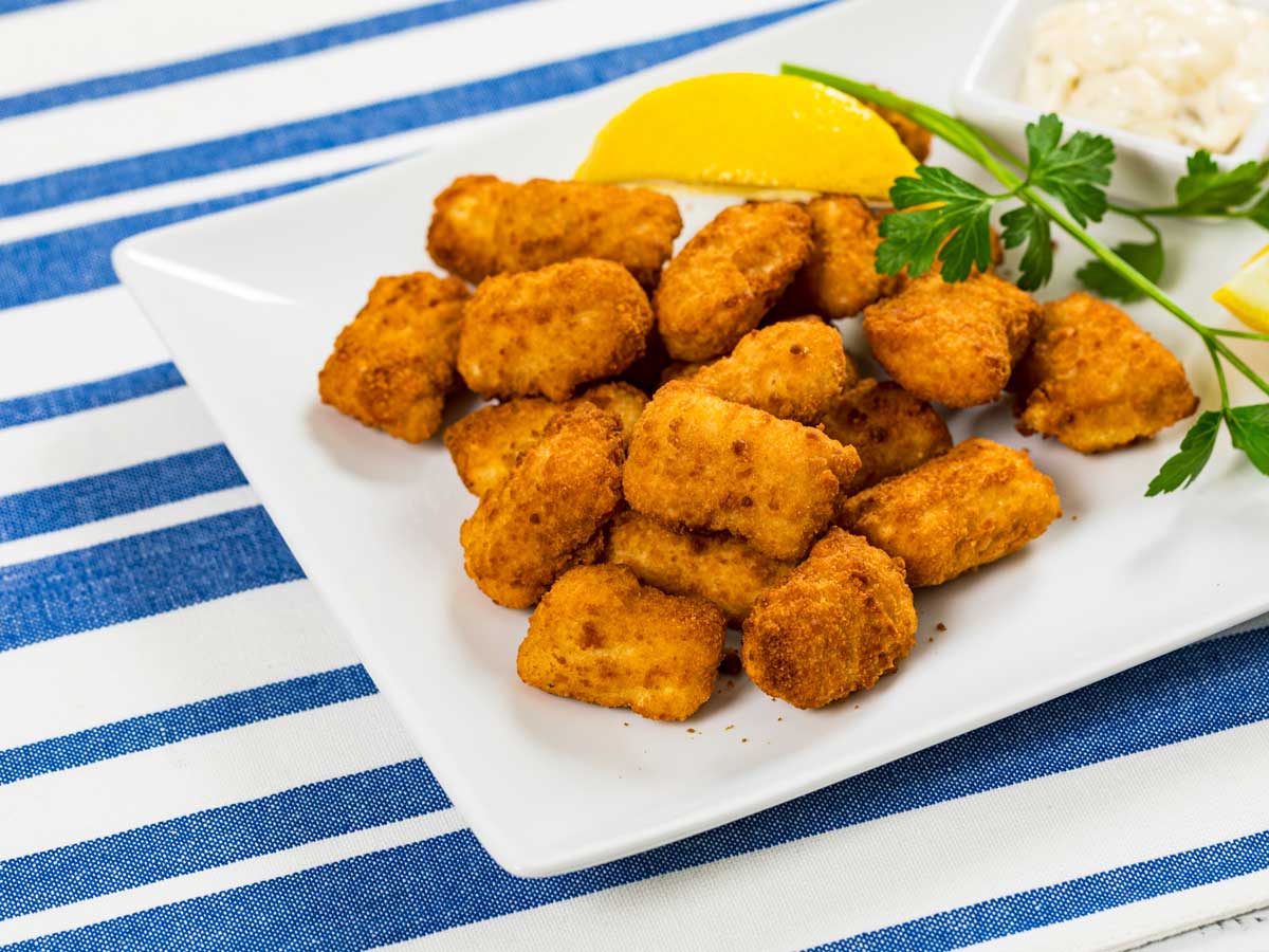 Gebakken kibbeling op een witte schaal.
