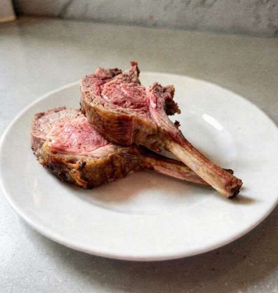 Mooi rosé gebakken lamskoteletten op een bordje.