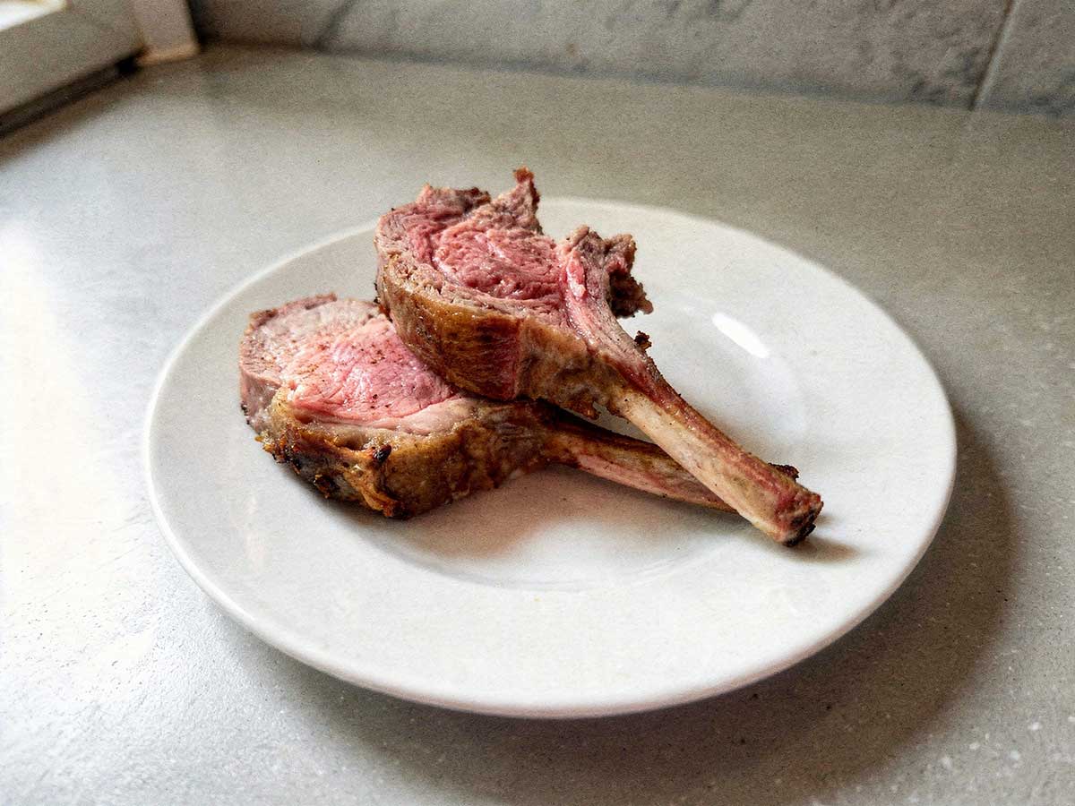 Mooi rosé gebakken lamskoteletten op een bordje.
