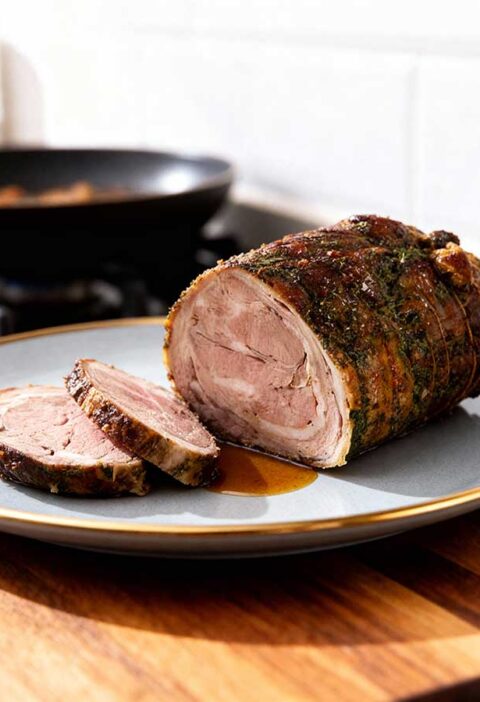 Een gebraden lamsrollade op een grijze schaal.