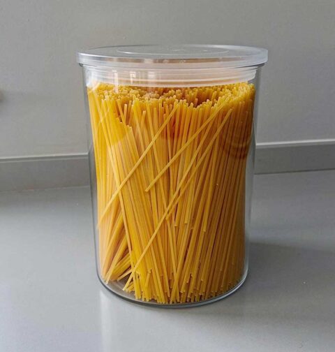 Gedroogde linguine, rechtop staand in een grote voorraadbus.