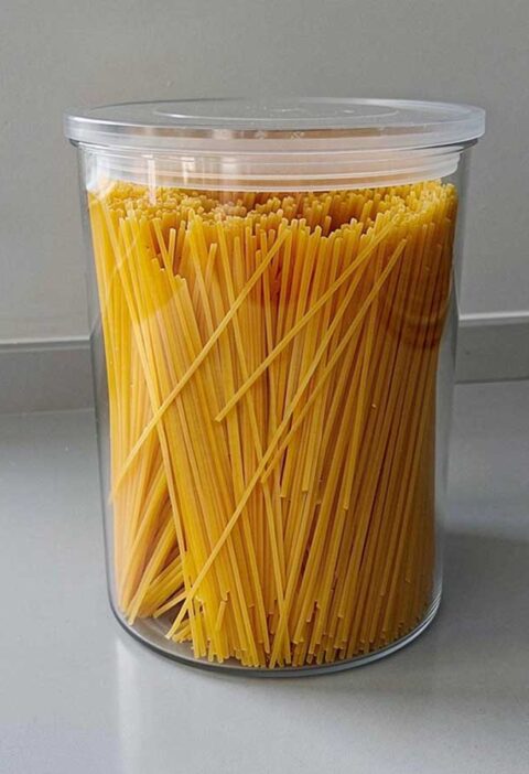 Gedroogde linguine, rechtop staand in een grote voorraadbus.
