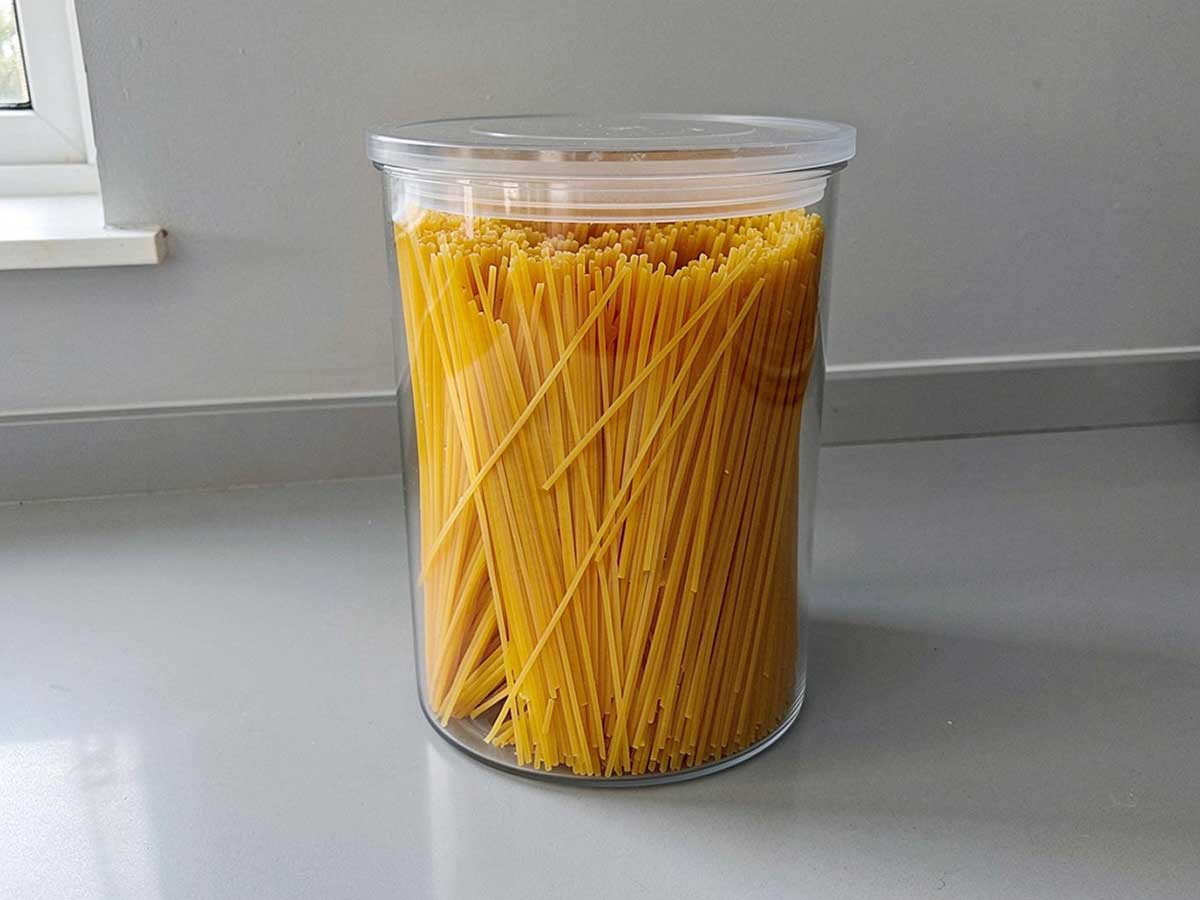 Gedroogde linguine, rechtop staand in een grote voorraadbus.