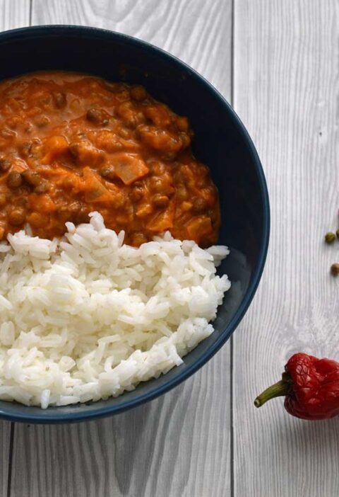 Linzencurry met rijst in een blauw schaaltje met allerlei pepers.