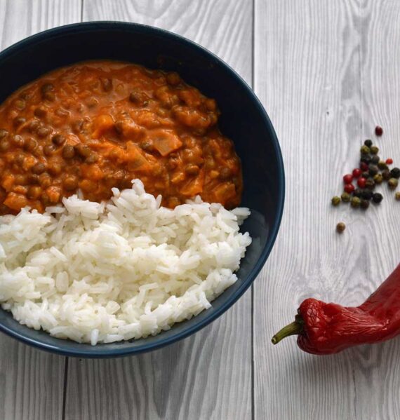 Linzencurry met rijst in een blauw schaaltje met allerlei pepers.
