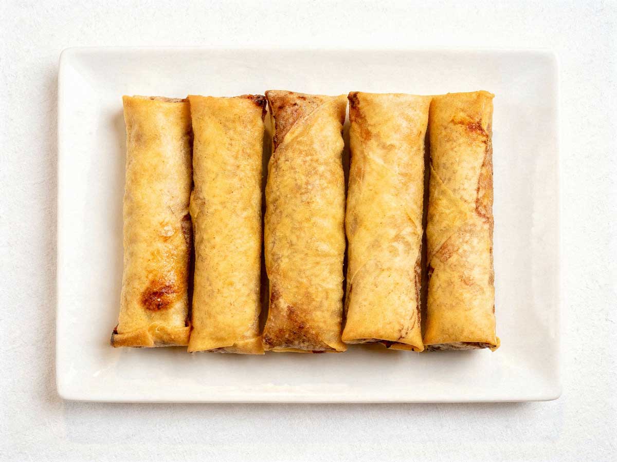 5 overgebleven loempia's op een schaal.
