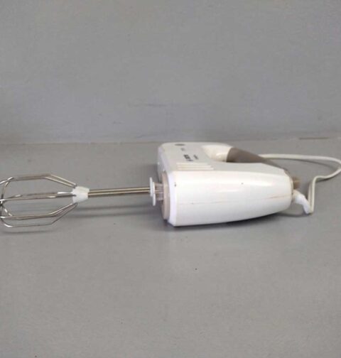 Een schone handmixer ligt op een werkblad.