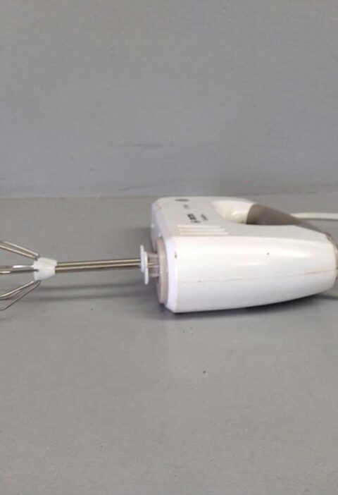 Een schone handmixer ligt op een werkblad.