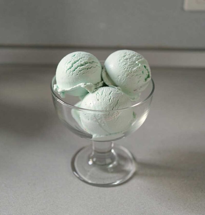 4 bollen zelfgemaakt munt roomijs in een glazen schaaltje.