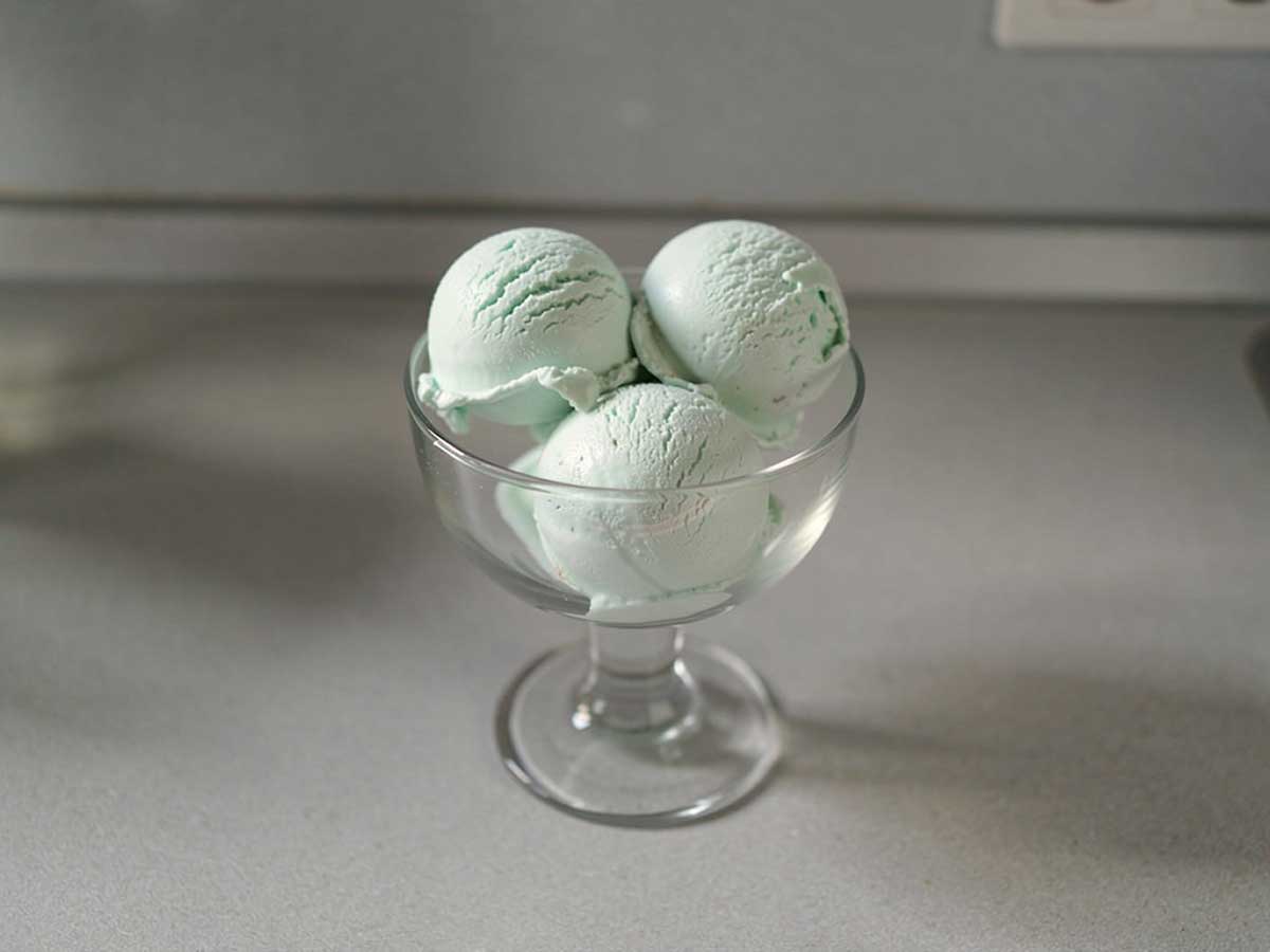 4 bollen zelfgemaakt munt roomijs in een glazen schaaltje.