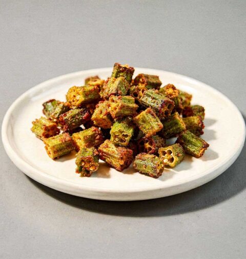 Een wit schaaltje met daarop gebakken okra.