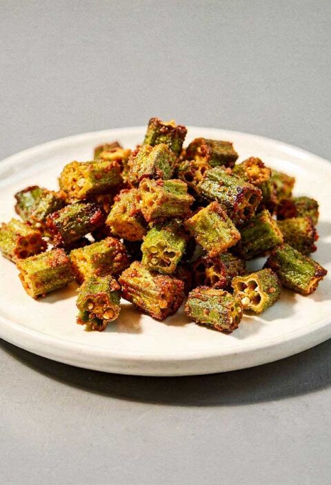 Een wit schaaltje met daarop gebakken okra.