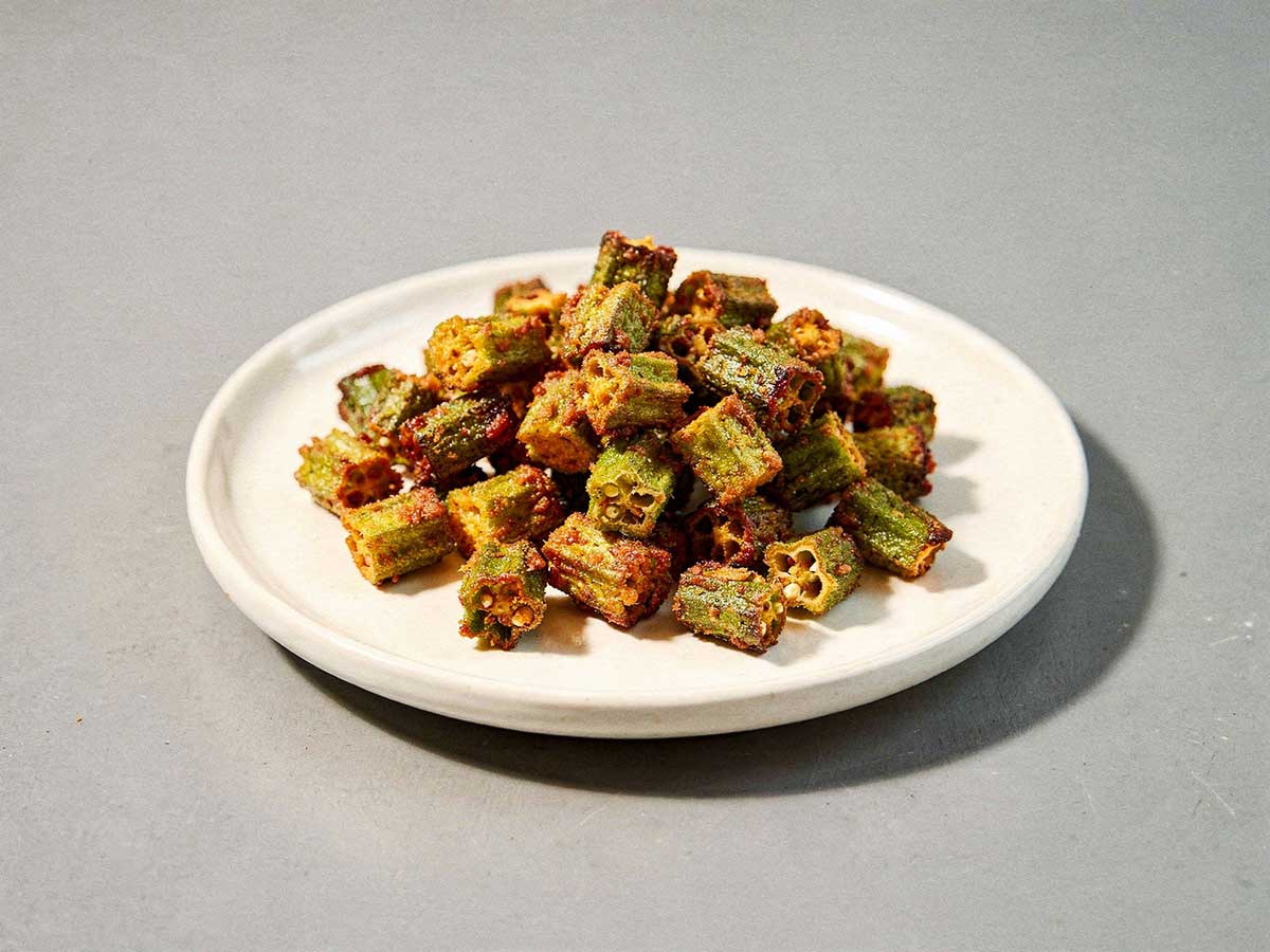 Een wit schaaltje met daarop gebakken okra.