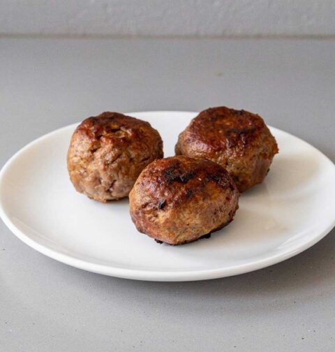 3 heerlijke gehaktballen liggen op een bord.