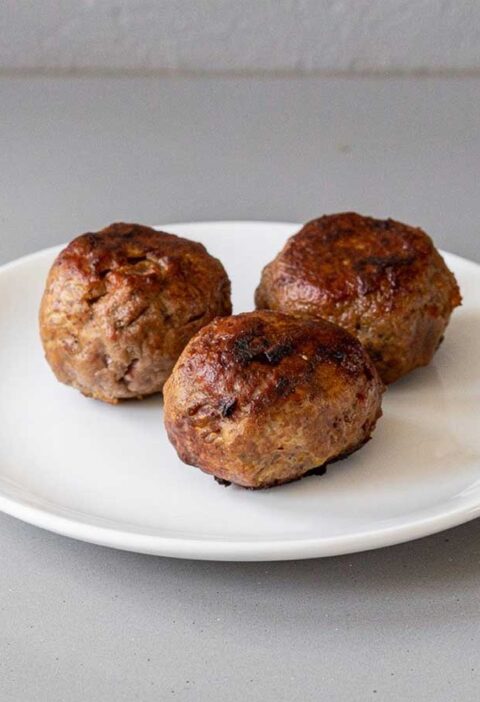 3 heerlijke gehaktballen liggen op een bord.