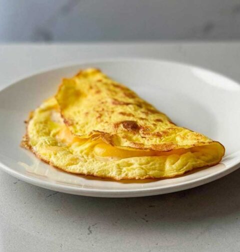 Een opgewarmd omelet op een wit bordje.