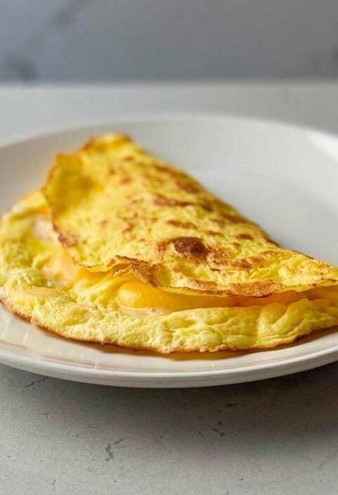 Een opgewarmd omelet op een wit bordje.