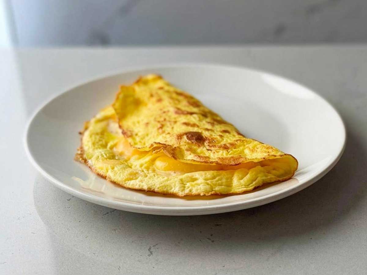 Een opgewarmd omelet op een wit bordje.