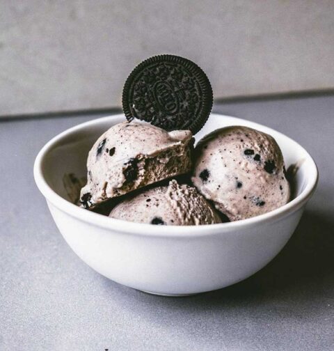 Een kom met zelfgemaakt oreo roomijs met een oreokoekje bovenop.