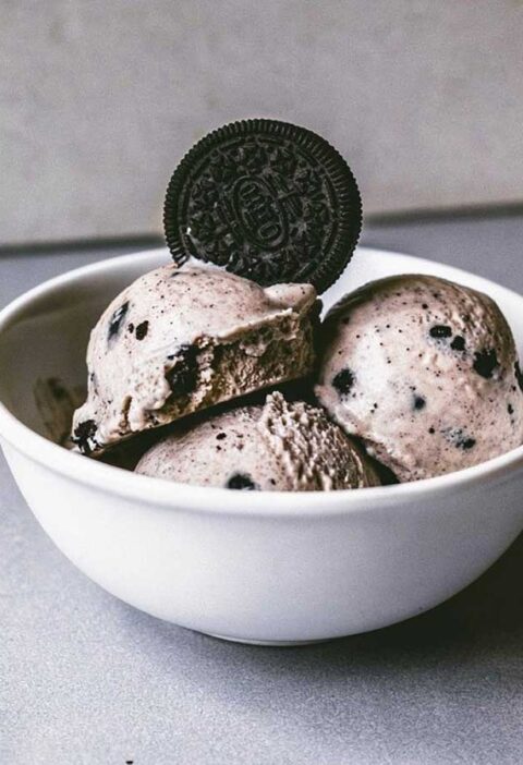 Een kom met zelfgemaakt oreo roomijs met een oreokoekje bovenop.