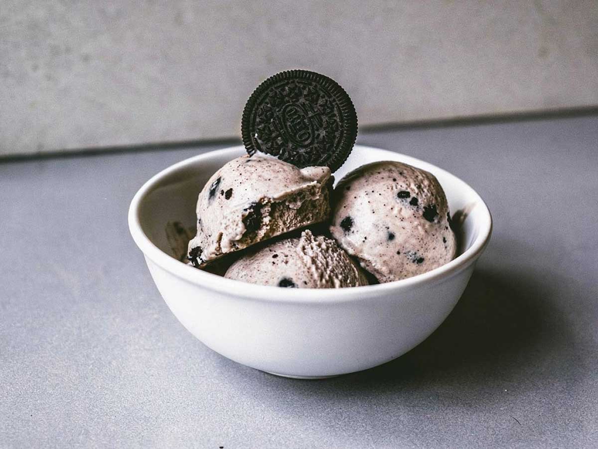 Een kom met zelfgemaakt oreo roomijs met een oreokoekje bovenop.