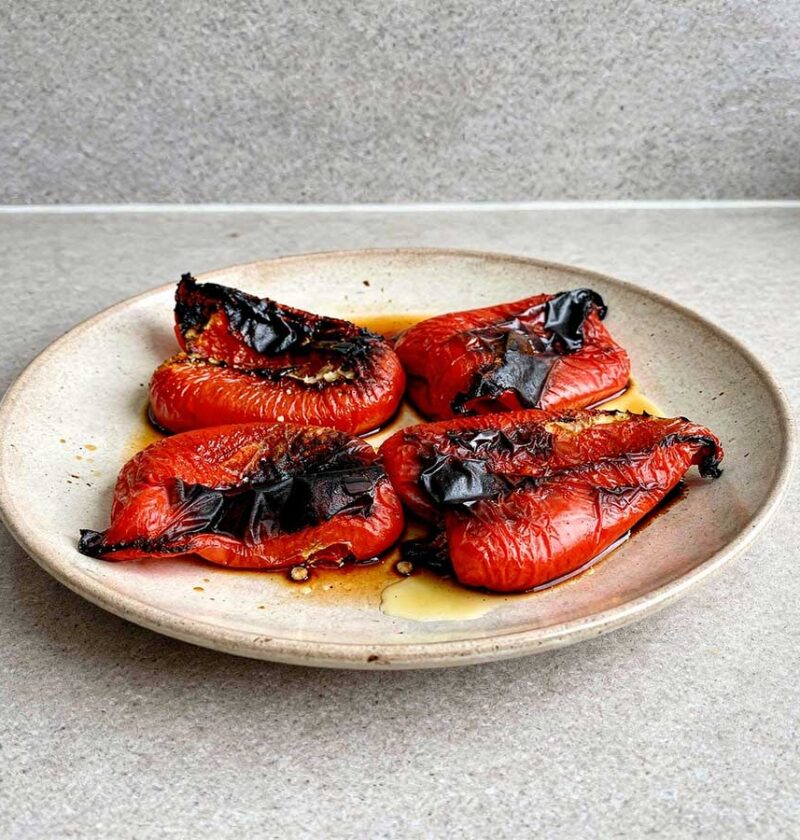 4 stukken geroosterde paprika op een bord.