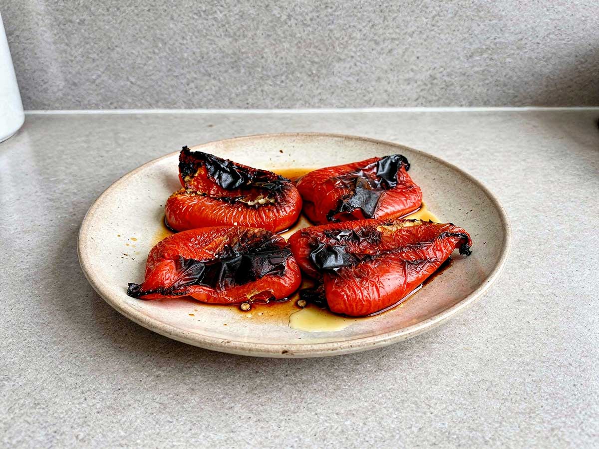 4 stukken geroosterde paprika op een bord.