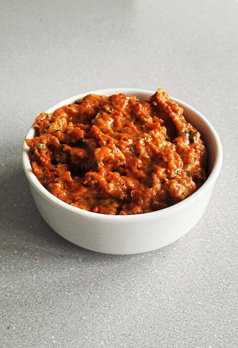 Een klein bakje met rode opgewarmde pesto.