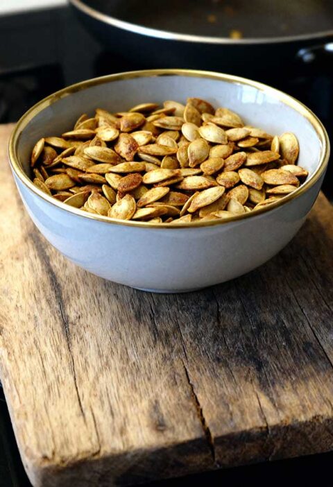 Geroosterde pompoenpitten in een grijs schaaltje.