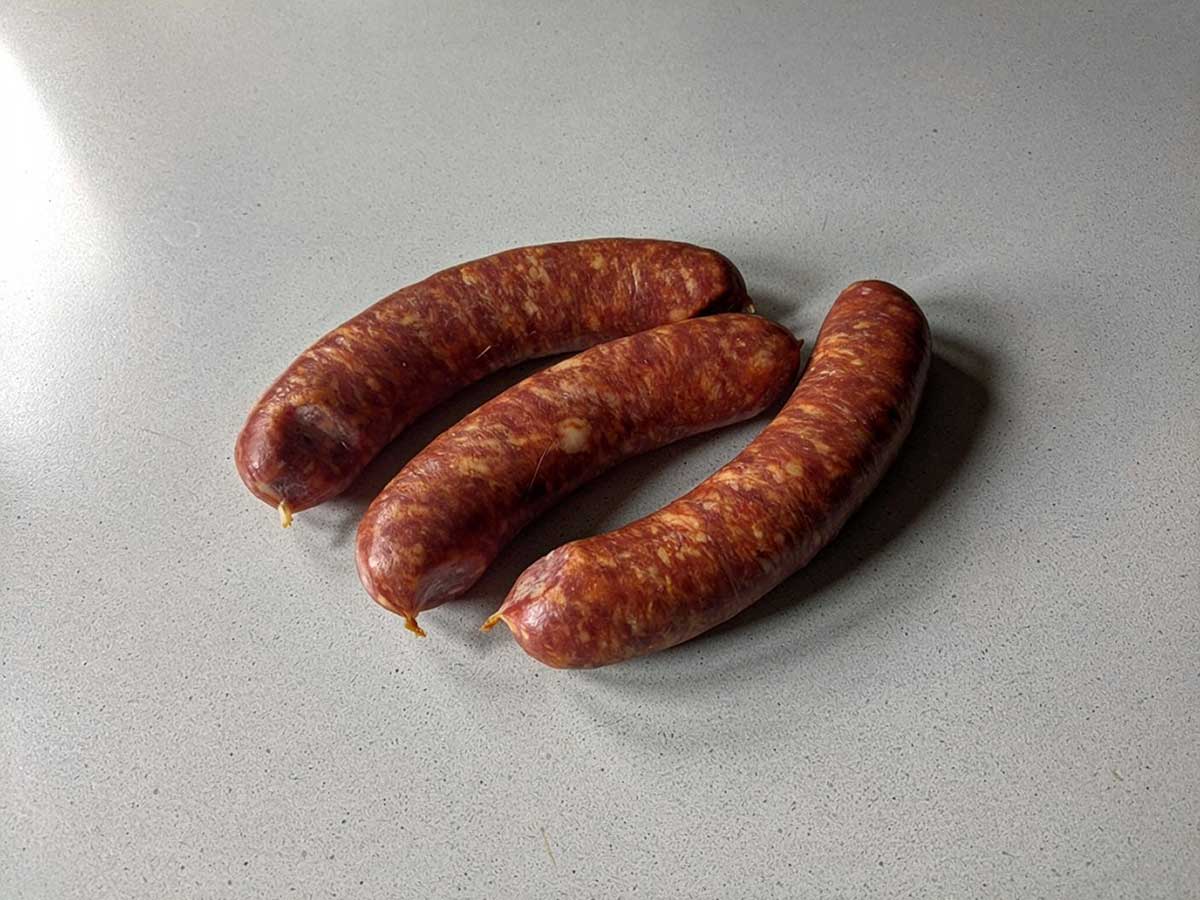 3 Poolse worsten liggen klaar om gebakken te worden.