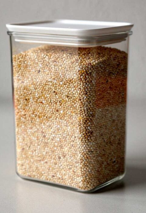 Een grote voorraadbus, gevuld met droge quinoa.