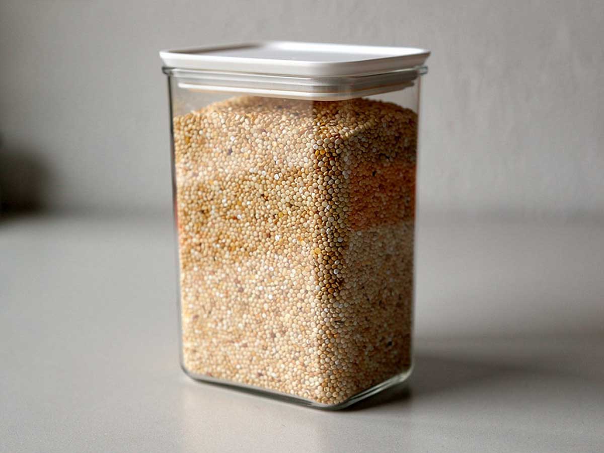 Een grote voorraadbus, gevuld met droge quinoa.