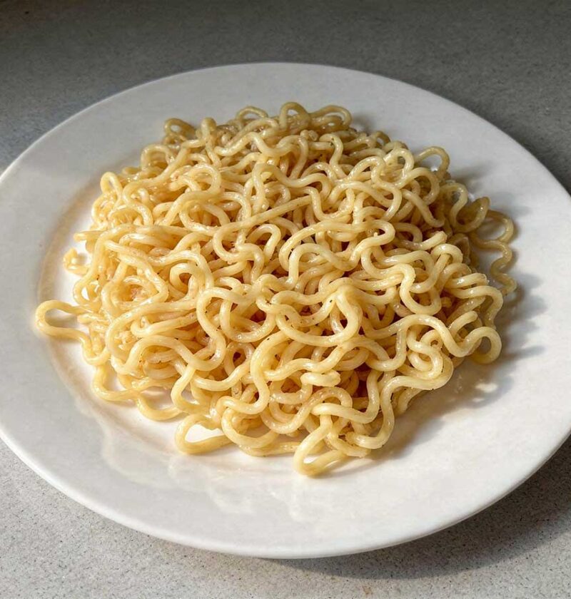 Een wit bord met een portie gekookgte ramen, klaar om verder te verwerken.