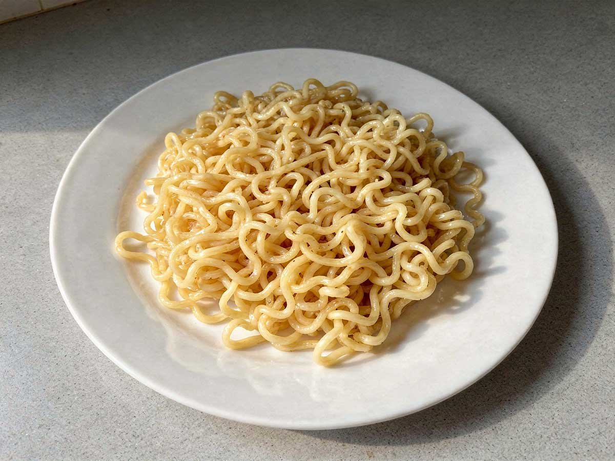 Een wit bord met een portie gekookgte ramen, klaar om verder te verwerken.