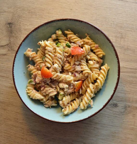 Een kom met gekookte fusilli en een heerlijke saus.