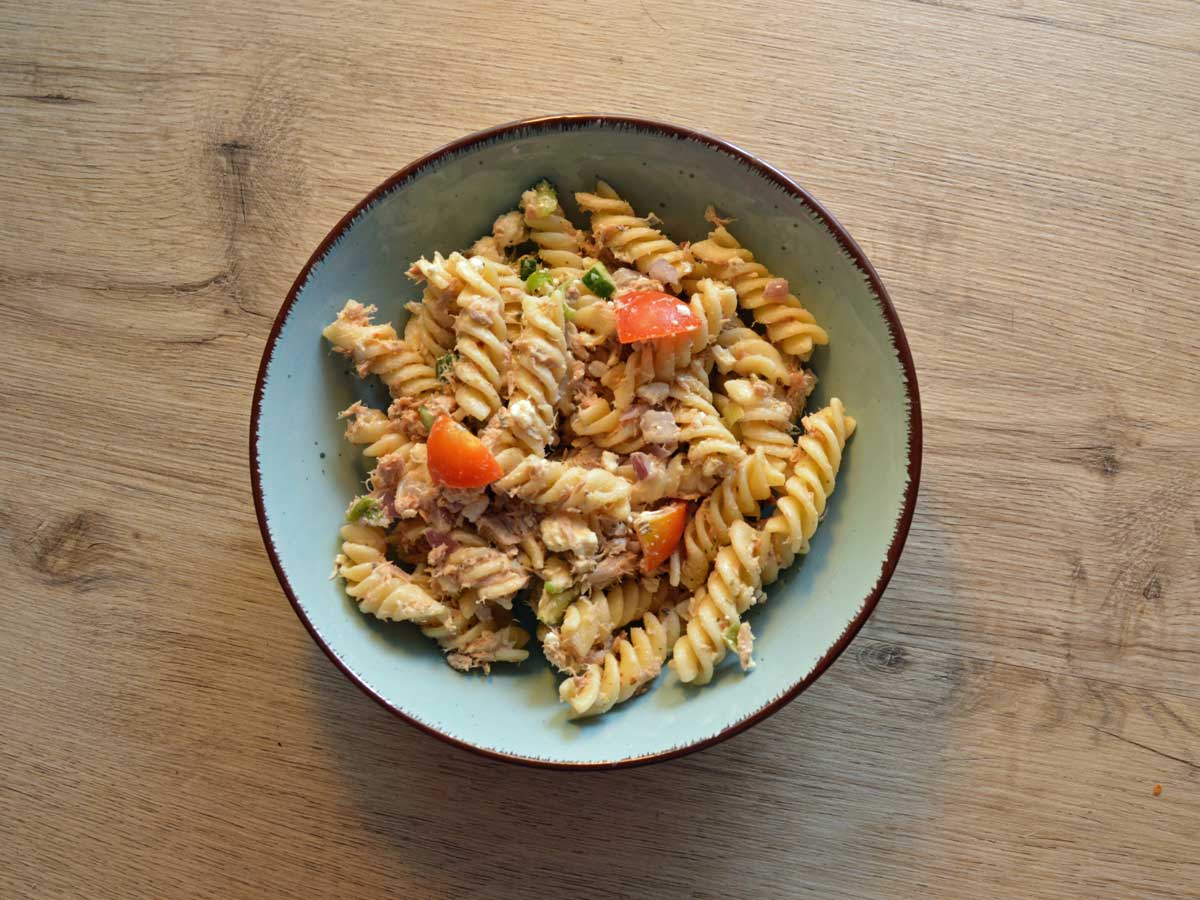 Een kom met gekookte fusilli en een heerlijke saus.