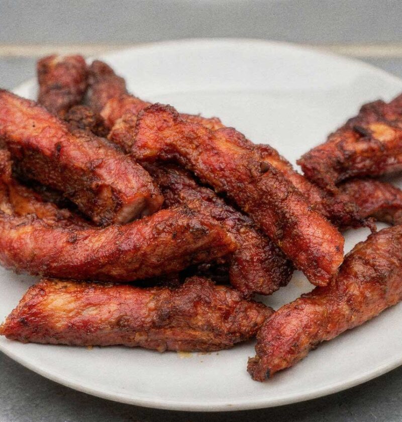 Gebakken ribfingers op een wit bord.