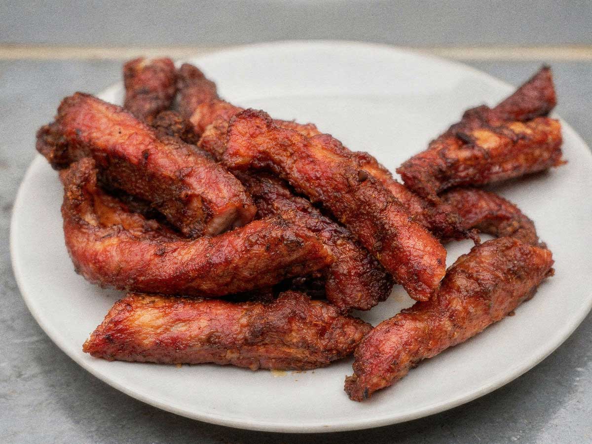 Gebakken ribfingers op een wit bord.