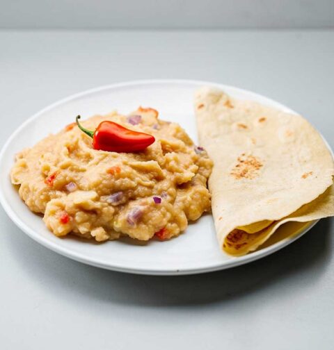 Een bord met sada edoes, met roti, en een rode peper.