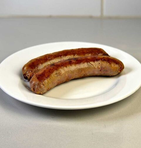 2 opgewarmde saucijsjes op een wt bord.