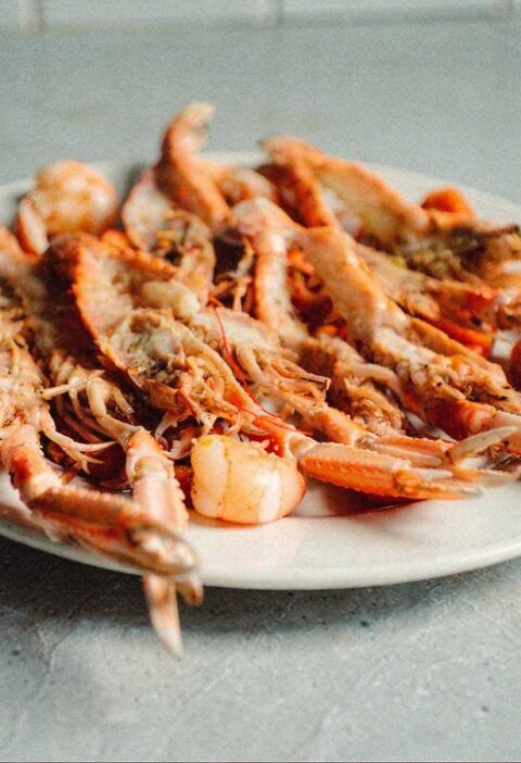 Een schaal met gehalveerde en gebakken scampi.