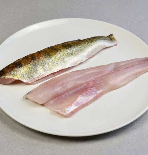 twee snoekbaarsfilets op een bord, bijna klaar om te bakken.