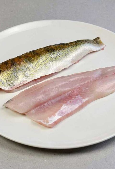 twee snoekbaarsfilets op een bord, bijna klaar om te bakken.