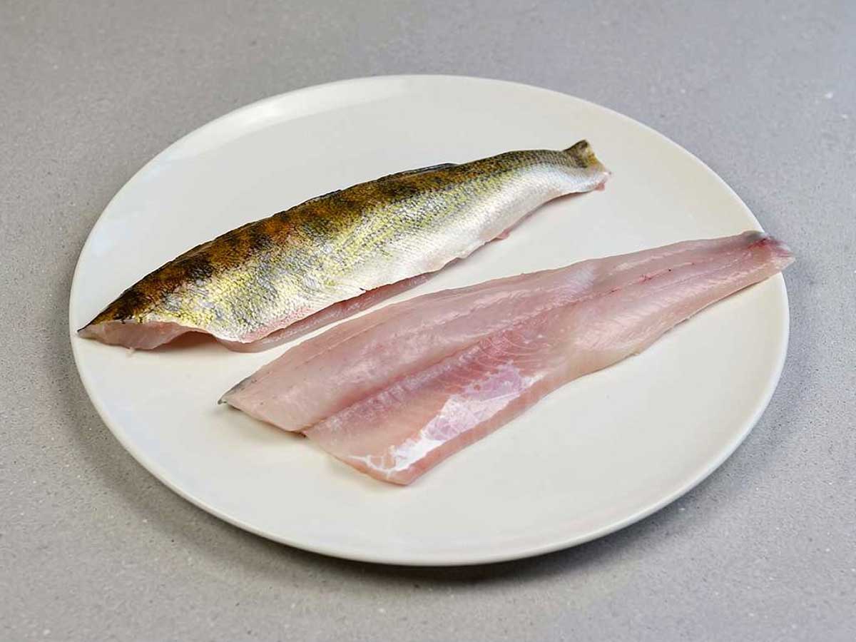twee snoekbaarsfilets op een bord, bijna klaar om te bakken.
