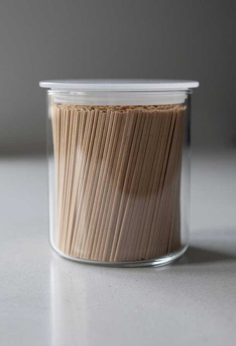 Een voorraadbus met gedroogde, rechtop staande, soba noedels.
