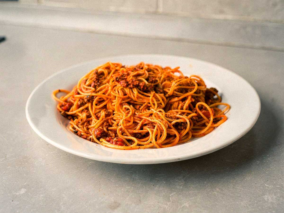 Een bord vol spaghetti met een tomatensaus.