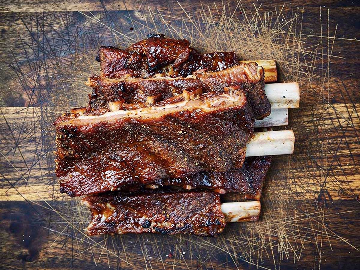 Opgewarmde spereribs op een houten ondergrond.