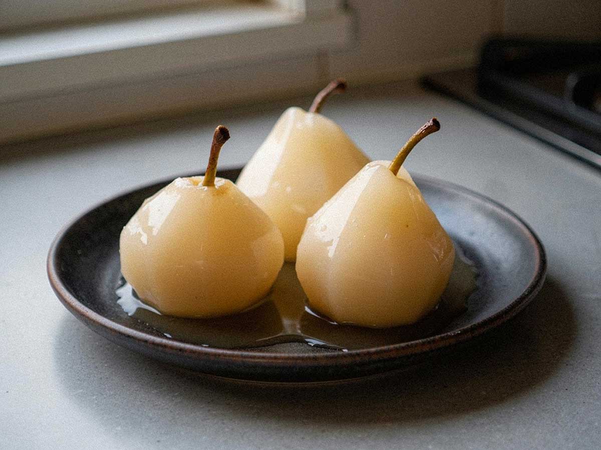 3 heerlijk gestoofde stoofperen op een wit bordje.