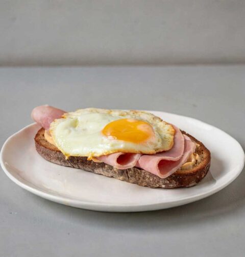 Een Strammer Max op een boterham op een wit bordje.
