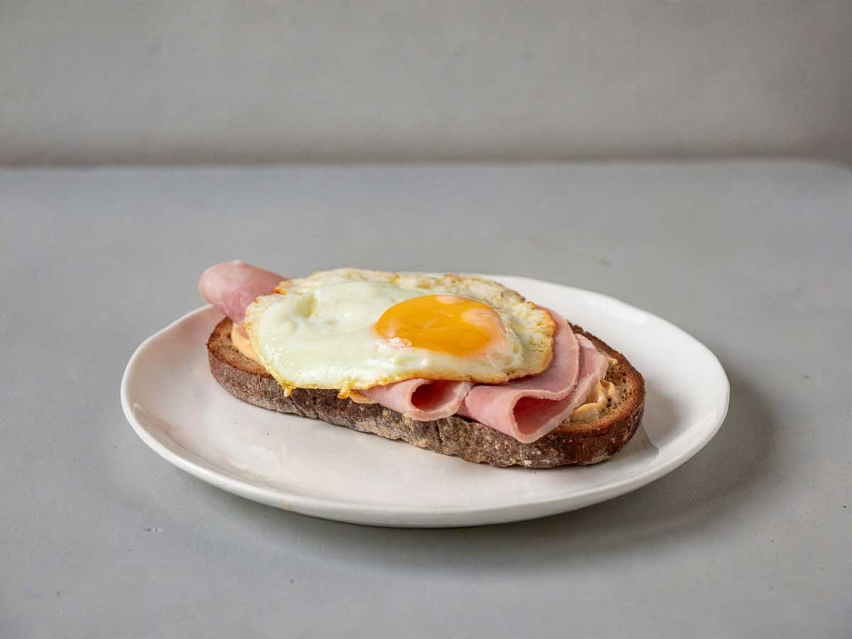 Een Strammer Max op een boterham op een wit bordje.
